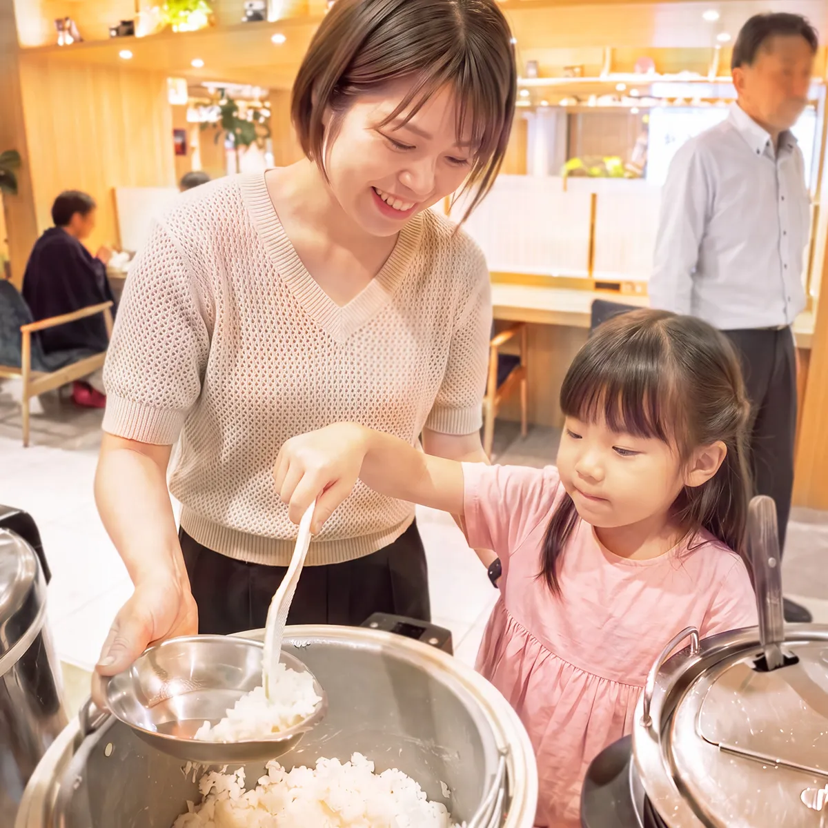 グランカスタマ上野店のイートインコーナーでカレーをよそる家族