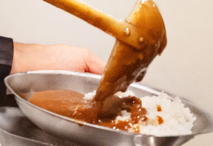 イートインコーナーでカレーをよそる様子